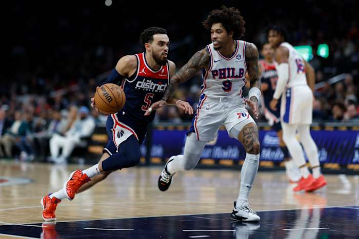 Washington Wizards guard Tyus Jones (5) drives to the basket as Philadelphia 76ers guard Kelly Oubre Jr. (9) defends in the second half at Capital One Arena. Mandatory Credit: Geoff Burke-USA TODAY Sports